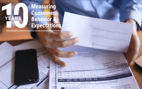 Video of a man going through a stack of bills. 10 years measuring consumer behavior & expectations text zooms in over the video.